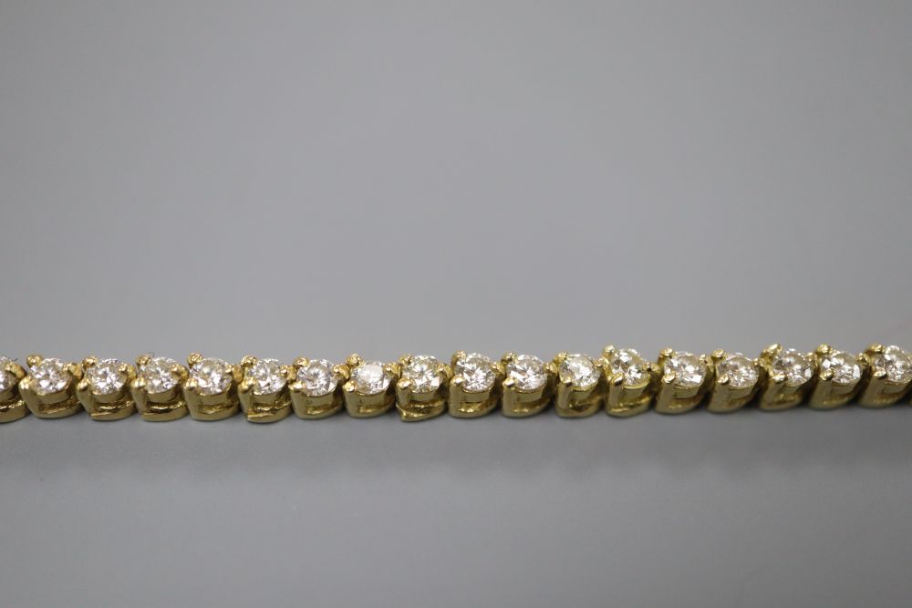 A modern 750 yellow metal and diamond set line bracelet, 18.5cm, gross 10.6 grams.